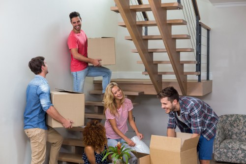 Furniture collection team handling a sofa pick-up in an Acton home