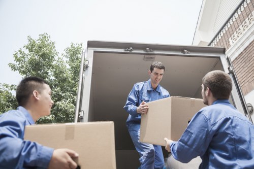 Professional movers handling boxes during an Acton flat relocation