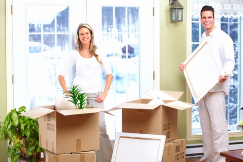 Professional moving crew using safe lifting methods and PPE